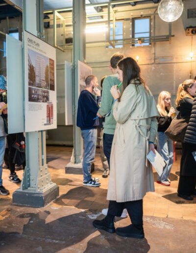 Kind en volwassene bekijken samen ontwerpplannen voor Baan 159–163 tijdens participatiebijeenkomst in Rotterdam.