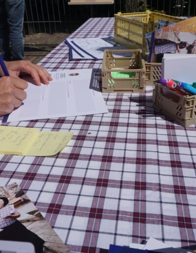 Deelnemer vult formulieren in tijdens MeeDenkDag in Bunschoten-Spakenburg, met flyers, stickers en schrijfmateriaal op tafel.