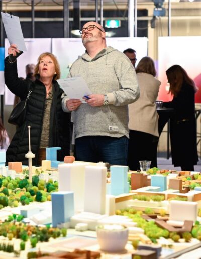 Bezoekers bespreken stadsmaquette van Parkhaven 010 tijdens publieksbijeenkomst over toekomstig ontwerp in Rotterdam.